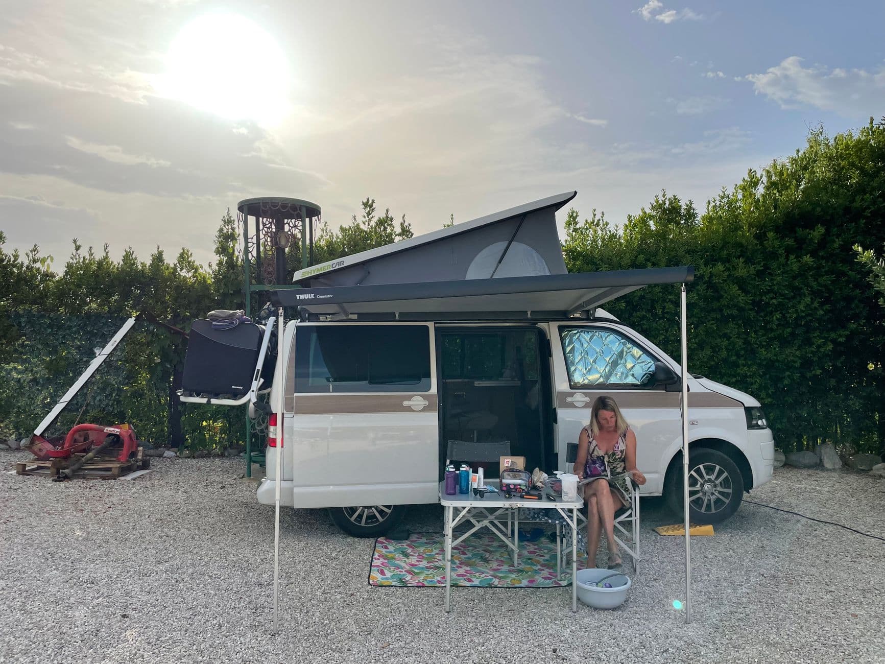 Een camper rijdt over een rustige weg tussen groene velden, klaar voor een nieuwe eigenaar.