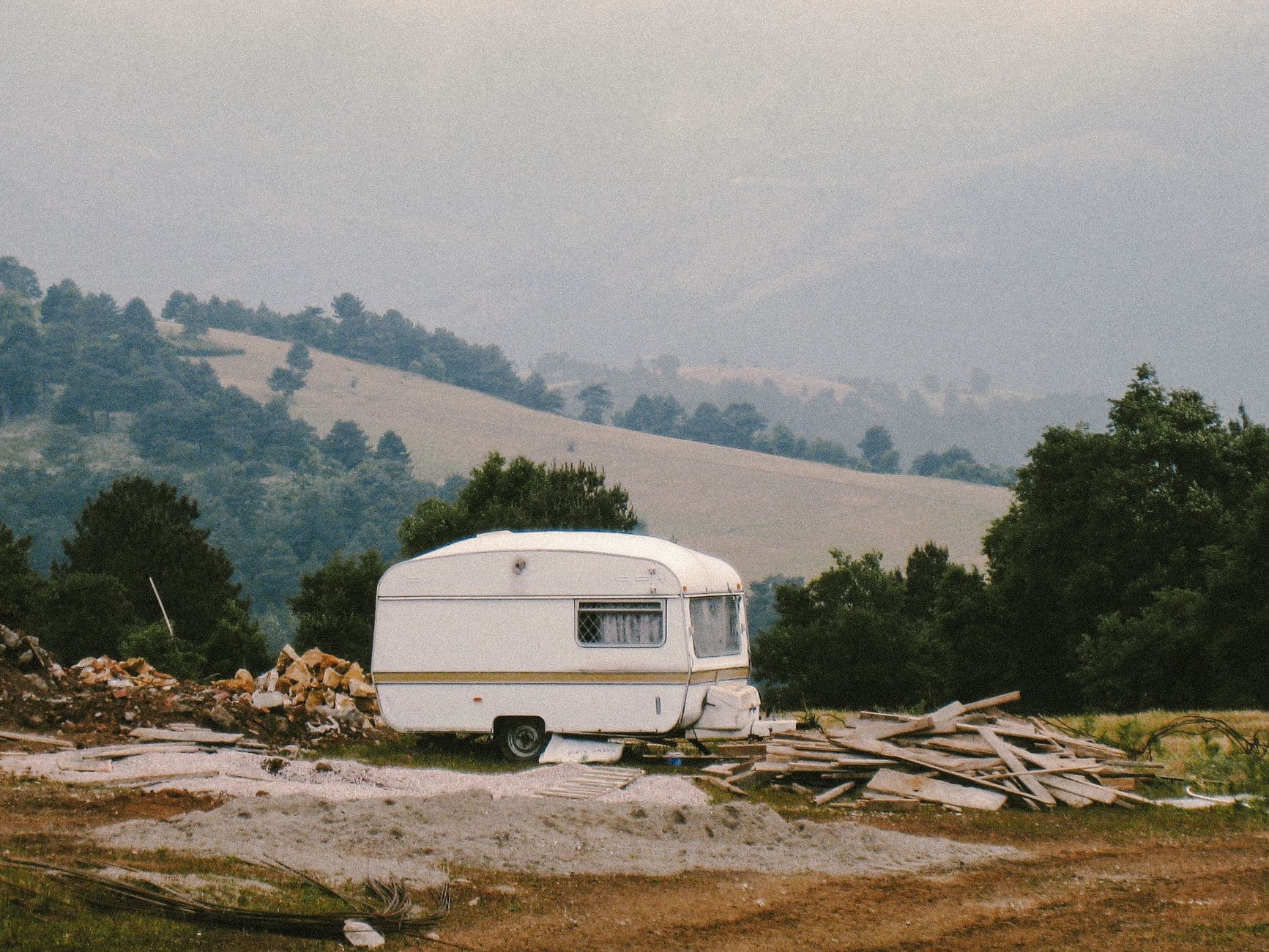 Een caravan staat aangekoppeld klaar voor transport op een zonnige dag.