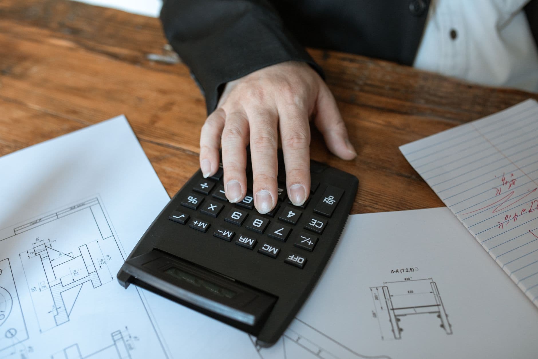 Iemand maakt aan tafel de jaarlijkse kostenberekening van een mobilhome.